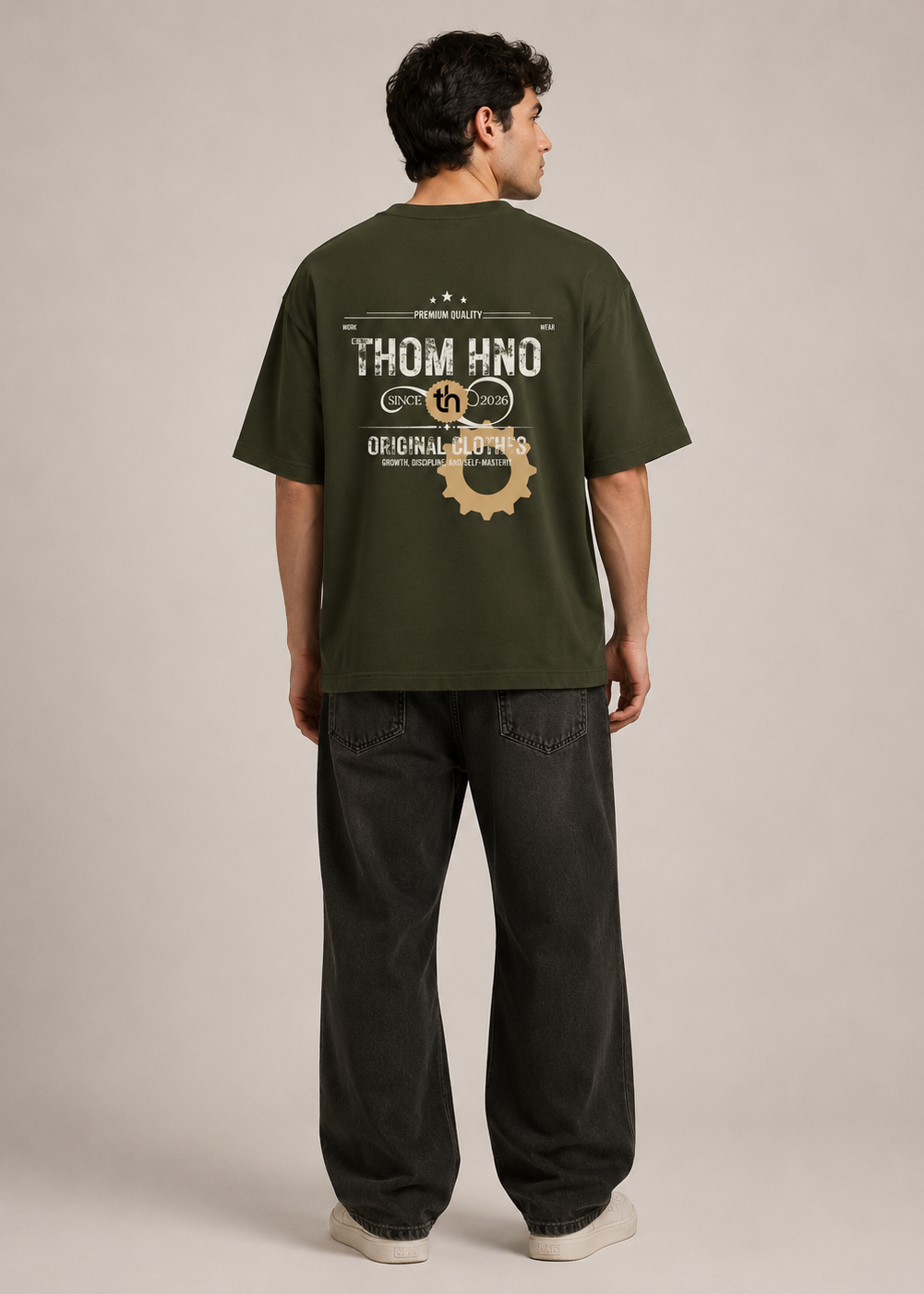 Man wearing a green t-shirt with branding on the back against a plain background